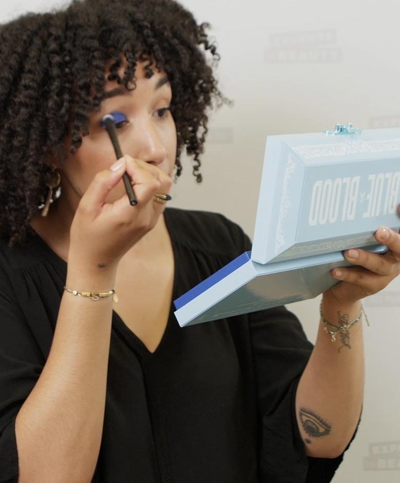 Beauty Expert Victoria brengt blauwe oogschaduw aan op haar wimpers