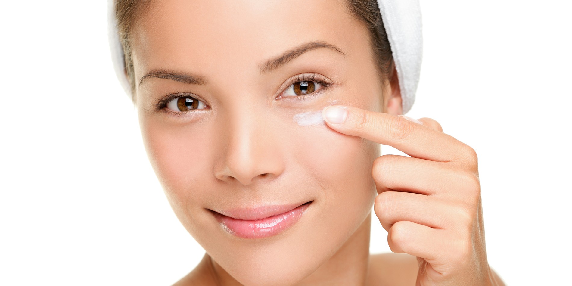 Face cream woman applying skin cream under eyes. Beauty eye contour cream, wrinkle cream or anti-aging skin care cream. Beautiful young mixed race Asian Chinese  beauty model in her 20s isolated on white background. Similar: