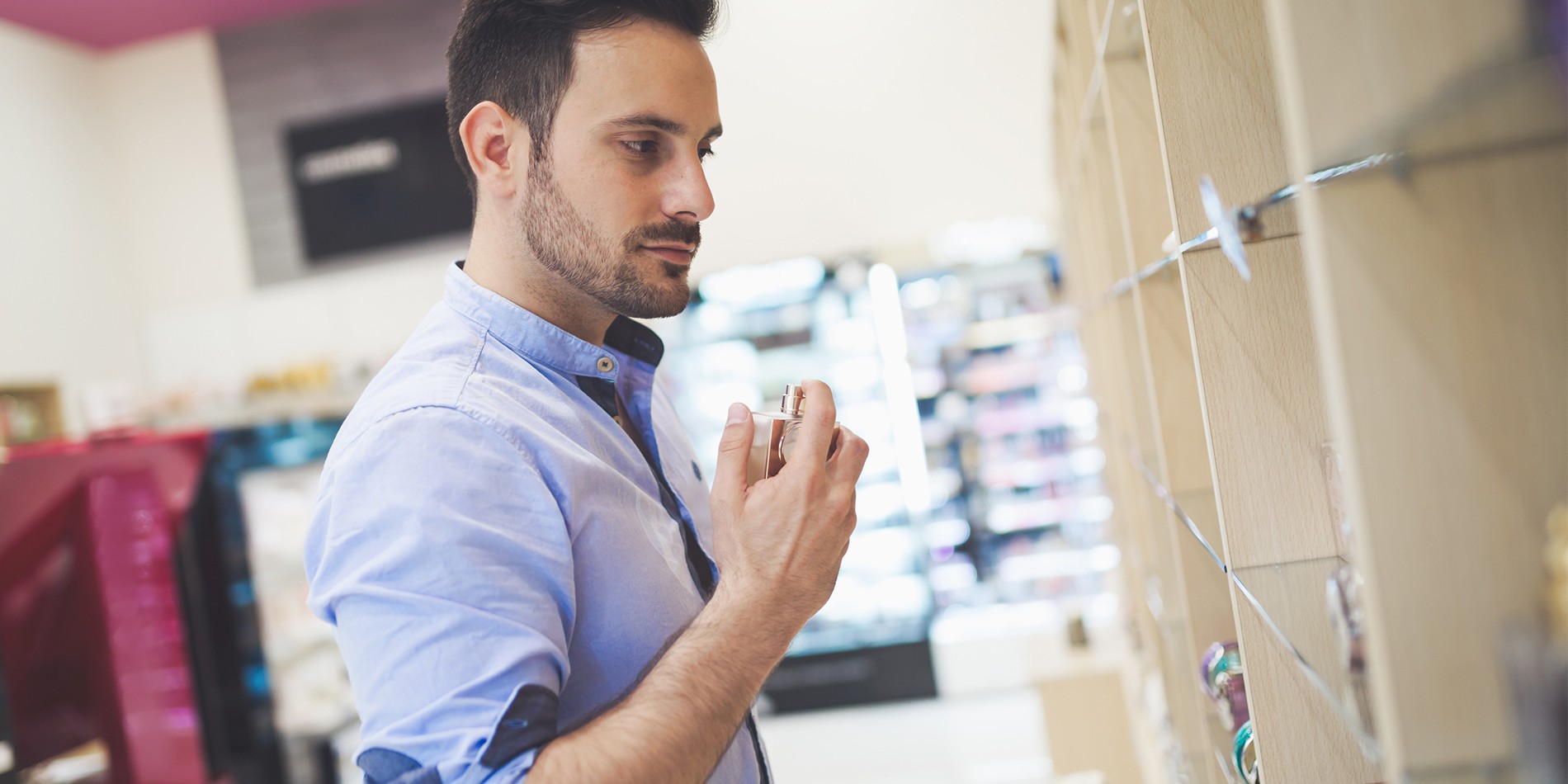 Handsome man shopping for fragrances in cosmetics store