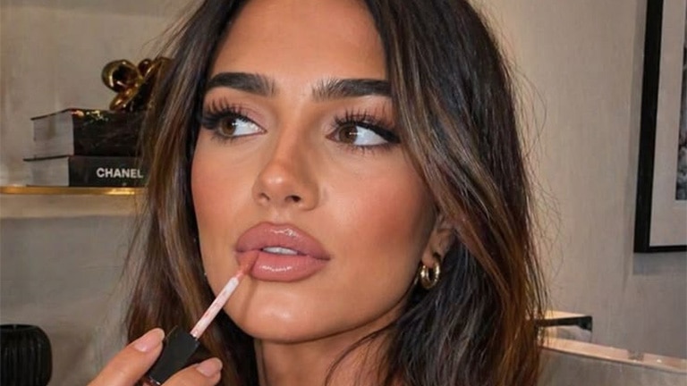 Vrouw brengt lipstick aan voor latte lips						 Vrouw brengt lipstick aan voor latte lips