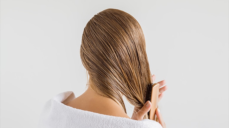 Vrouw borstelt nat haar Vrouw borstelt nat haar