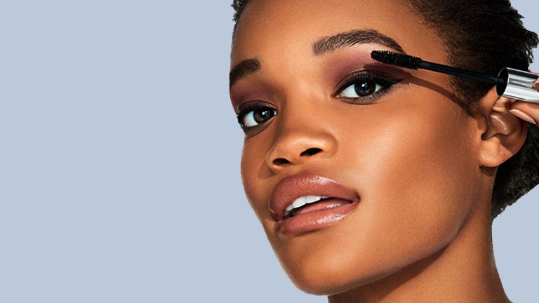 Close up van een gezicht van een vrouw met een mascara borstel Close up van een gezicht van een vrouw met een mascara borstel