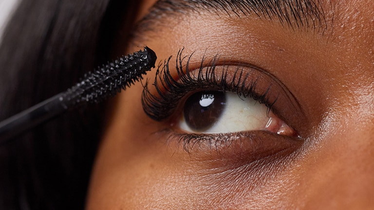 Close up van een gezicht van een vrouw met een mascara borstel Close up van een gezicht van een vrouw met een mascara borstel